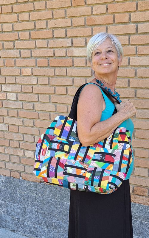 Professora de patchwork apresentando bolsa feita com micro retalhos