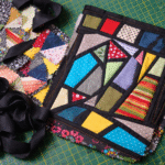Patchwork mosaico feito com micro retalhos coloridos e tiras pretas criando tecido estruturado