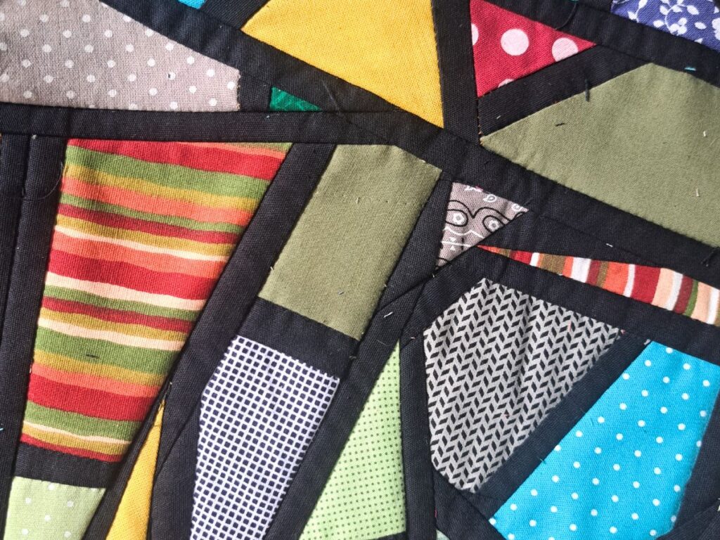Tecido em patchwork mosaico feito com micro retalhos e moldura preta